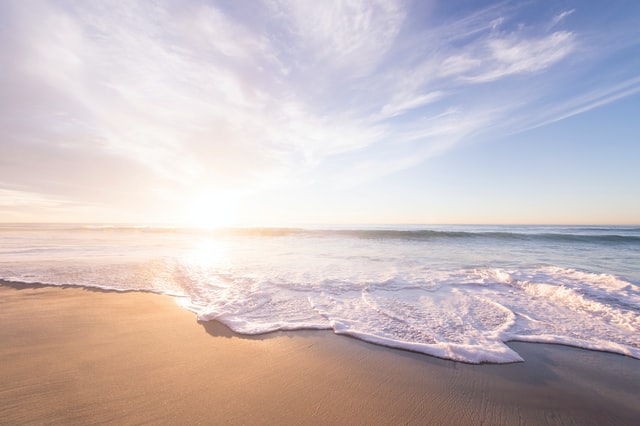 太陽の光に照らされている砂浜の画像