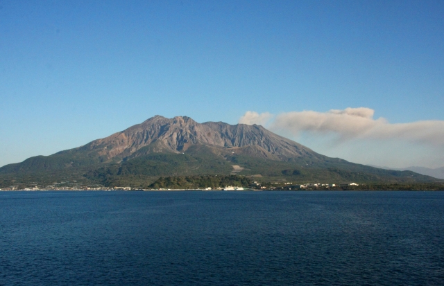 鹿児島市側から見た大きくそびえたつ桜島と真っ青な鹿児島湾の画像