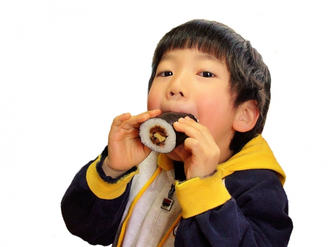 恵方巻きを丸かじりしている子供の画像