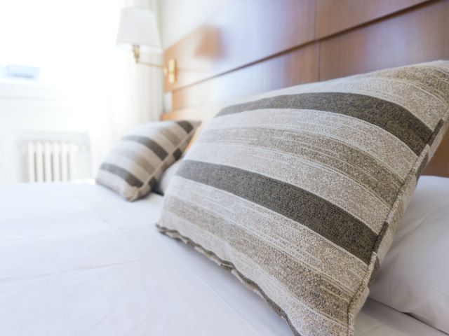 ホテルの寝室、ストライプの枕のベッド