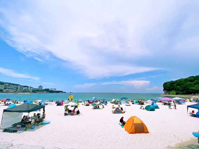 夏の混雑したビーチ、テントが並んでいる画像
